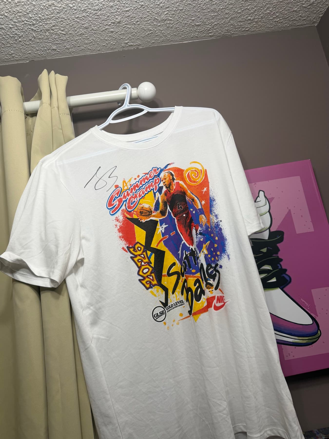 A white Scottie Barnes Summer Camp t-shirt on a hanger, signed in silver marker