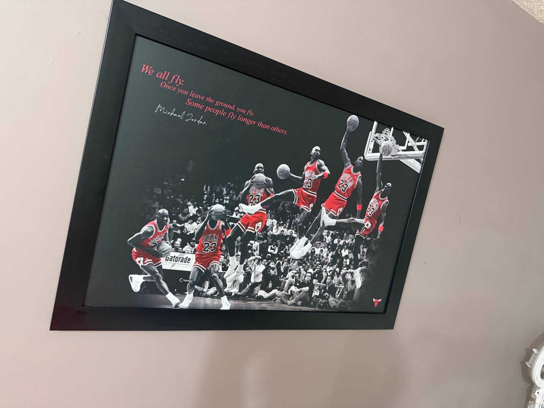 Framed Michael Jordan print showing a sequence of a dunk, with the quote We all fly
