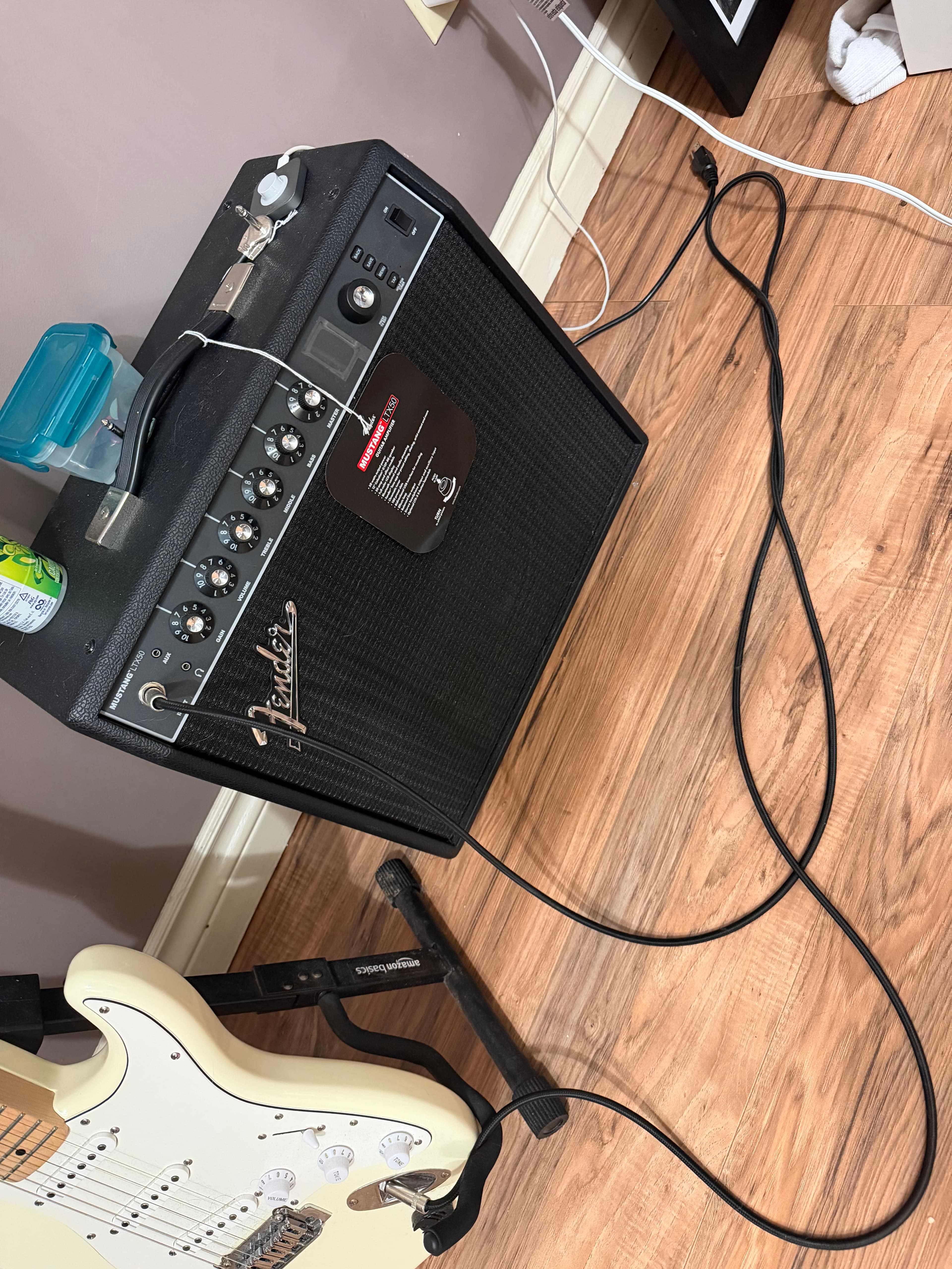 Fender Mustang LT X50 guitar amplifier with the Stratocaster on a stand beside it